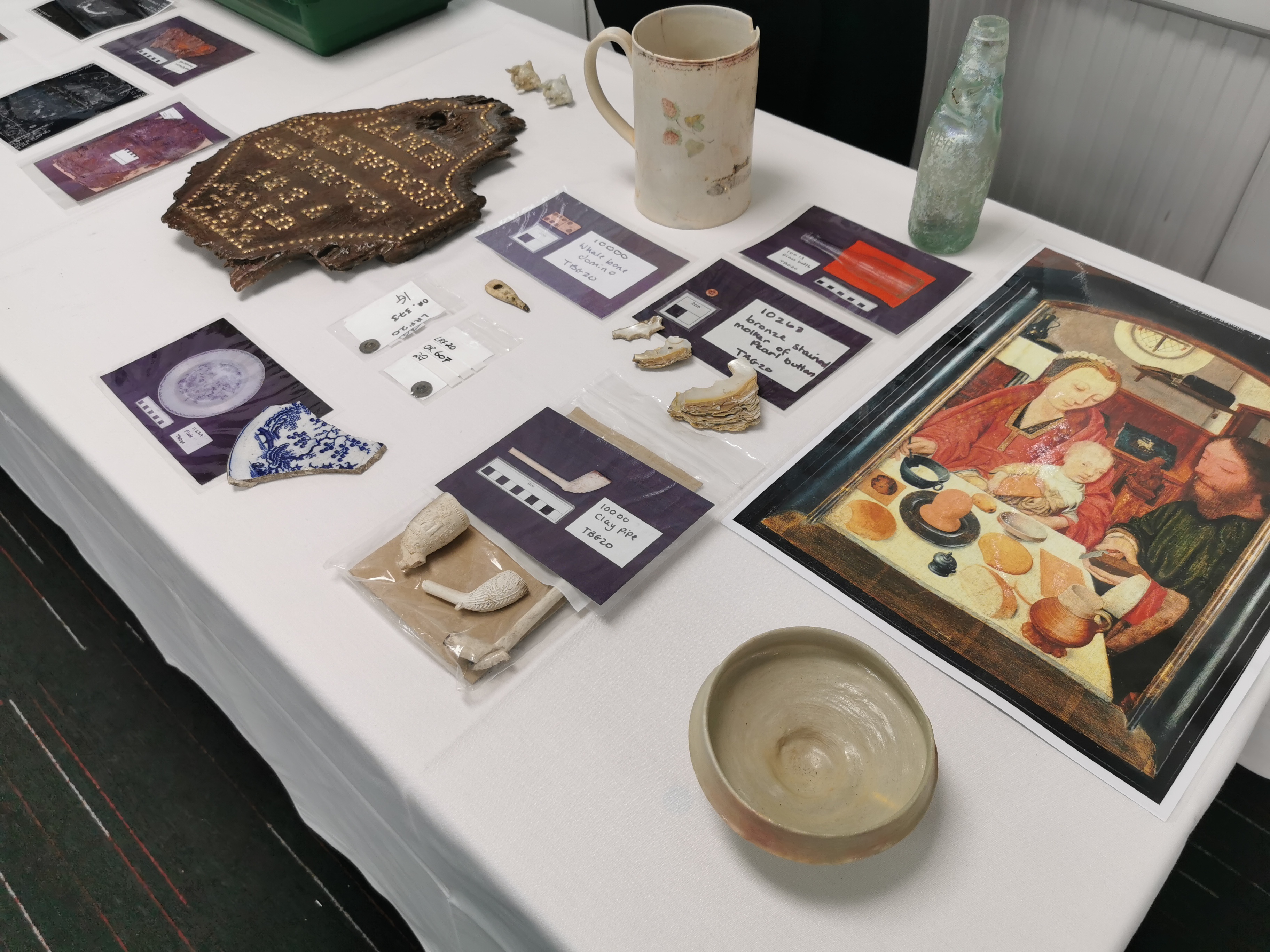 The finds table, showing replicas kindly loaned by Hull Minster, such as the Seigburg bowl, alongside images of finds from Trinity Burial Ground and comparative objects from our handling collection.