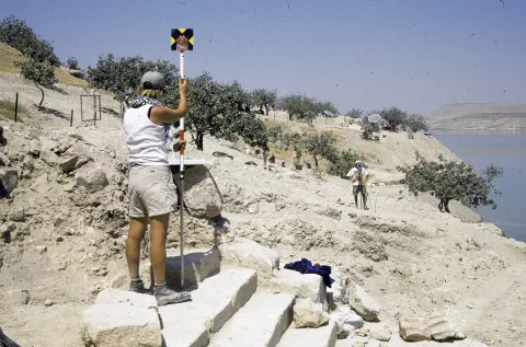 Archaeologists surveying the site with stepped road in the foreground