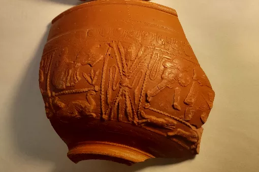 Samian pottery sherd with gladiators, running dogs and chariot