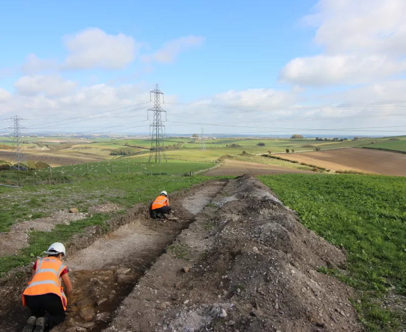 Archaeologists excavating evaluation trench on route of Dorset Visual Impact Provison project 