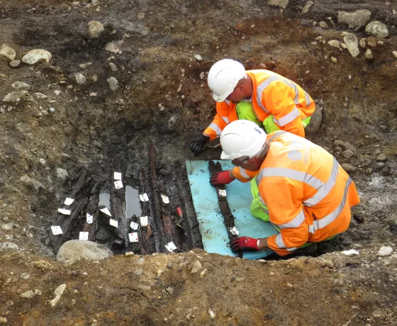 Archaeologists excavate timbers from the burnt-mound trough