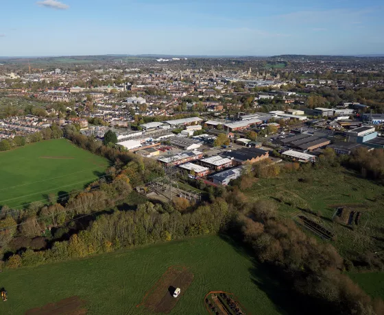 Oxford Flood Alleviation, aerial view. Evaluation trenches in the foreground, then Osney Mead Industrial Estate in the mid-ground with Oxford in the distance