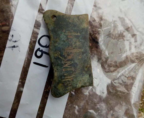 This buckle plate represents a tangible trace of a potentially identifiable individual from the camp: J T Miller, who carved their name on to the object.